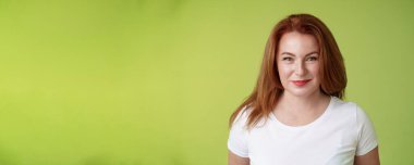 Hevesli, gülümseyen, orta yaşlı, neşeli, sırıtan bir kadın. Çekici güdümlü kamera hedefe ulaşmayı hedefliyor. Mutlu bir şekilde oyun oynayan torunun mükemmel bir aile yeşil arka planına sahip olmasını izliyor.