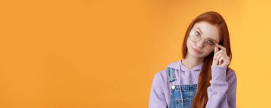 Sinirli, patronluk taslayan, etkilenmemiş, genç, kızıl saçlı, sırıtan, sırıtan, sinirli, dokunmatik gözlükler..