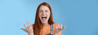 Lifestyle. Pissed outraged moody redhead girl shouting complaining angry standing bothered screaming out loud close eyes yelling loudly raising hands sideways dismay full disbelief feel cheated