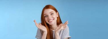 Aptal, sevimli, samimi, Avrupalı, genç, kızıl, mavi gözlü kız ellerini silkip, yüzün yakınına yayılmış, özür dileyen, yaltaklanan, özür dileyen, geç kalan, aptalca bahaneler üreten, mavi arka plan..