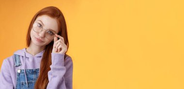 Sinirli, patronluk taslayan, etkilenmemiş, genç, kızıl saçlı, sırıtan, sırıtan, sinirli, dokunmatik gözlükler..