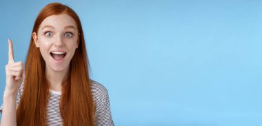 Heyecanlı, güzel görünümlü, neşeli kızıl kız arkadaş fikir sohbeti ekle işaret parmağı eureka hareketi aç ağzını aç ve telkin et geniş bir gülümsemeyle mükemmel bir değişken, mavi arka plan.