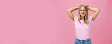 İnatçı kız asla hayallerini yıkmaz. Çekici, heyecanlı ve kaygısız, iyimser, bronz tenli, göz kırpan dilli, boynuz gibi işaret parmakları tutan genç bir kadın. Vücut