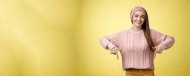 Genç, 20 'li yaşlarda, hırkalı, sırıtan Avrupalı bir kız nihayet yetenekli dişçi profesyonelini tanıtan diş tellerini indiriyor. Sarı duvarın üzerinde mutlu bir şekilde duran kız öğrenci..