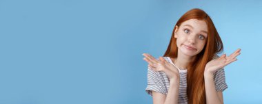 Yaşam tarzı. Aptal, aptal, aptal, aptal, aptal, yarı zamanlı çalışan, omuz silken, dikkatsiz, sırıtmayan kaşlarını kaldıran, kafası karışık kadın, mavi arka plan hakkında hiçbir şey bilmiyor.