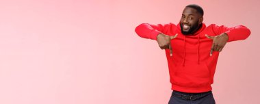 Şımarık, genç, karizmatik, sakallı, kırmızı kapüşonlu siyahi adam işaret parmağıyla işaret ediyor. Harika bir kopya alanı çözümü sergiliyor..