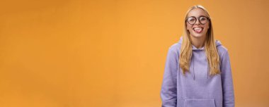 Eğlenceli kadın programcı, öğle arasında iş arkadaşlarının etrafında dolanıyor. Kocaman gülümsüyor, sevimli gözlüklerle gülüyor, mor kapüşonlu, mor arka planda duruyor..