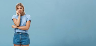 Yaşam tarzı. Stüdyodaki mutsuz, huysuz sevgili, hayal kırıklığına uğramış sevgili şımarık sevgili, tatminsizlikten suratını ekşiterek ve gözlerini kısarak mavi üzerine poz verdirerek.