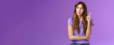 Katı, kıvırcık saçlı, hayal kırıklığına uğramış suratını çeken, kızgın, patlak gözlü, kameraya bakan, işaret parmağı sallayan, kınayan, kötü davranışları azarlayan, ciddi, mor bir geçmişi olan bir kız..