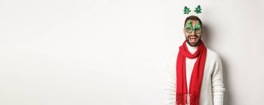 Noel, yeni yıl ve kutlama konsepti. Yakışıklı sakallı adam şaşırmış görünüyor. Parti gözlüğü ve aksesuar takıyor. Beyaz bir geçmişi var..