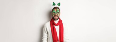 Noel, yeni yıl ve kutlama konsepti. Yakışıklı sakallı adam şaşırmış görünüyor. Parti gözlüğü ve aksesuar takıyor. Beyaz bir geçmişi var..