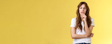 Durumu nasıl çözeceğimizi düşünmeliyiz. Kafası karışmış, ciddi görünümlü, düşünceli, dudak büken, düşünceli, düşünceli, sarı arka plan tereddütlü bir kadın. Boşluğu kopyala