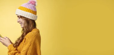 Profil, sempatik, rahat, çağdaş genç bir kızı elinde akıllı telefonuyla gülümseyerek mesajlaşırken, eğlenceli bir kurgu resmi görüntülerken çekti. İnternet 'te blogcu mesajlaşmacı takipçileri.