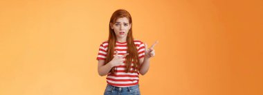 Kendine güveni sarsılmış, sinirli, tatlı, kızıl saçlı bir kız şüpheli, suratsız, kuşkulu ve tereddütlü, kamerayı şaşırmış bir şekilde gösteren, soru soran şüpheli bir kız..