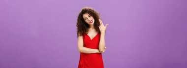 Kurallar beni öldürüyor. İsyankar, ateşli ve şık Avrupalı, zarif kırmızı elbiseli, kıvırcık saçlı, parmak tabancasıyla hareket eden, mor arka planda can sıkıntısından beyin üfleyen bir kadın.