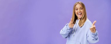 Hevesli ve karizmatik bir kadın, arkadaşlarıyla buluşup havalı fotokopi salonunu kontrol ederken, kamerayı işaret ederek mor duvarın üzerinde şık kapüşonlu bir şekilde poz veriyor. Boşluğu kopyala