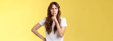 Konser sırasında konuşmak yok. Ciddi görünümlü, hoşnutsuz yetişkin kardeş talebi. Sessiz, sessiz, sessiz, parmak basılmış dudaklar çatık, kızgın, sarı arka plan..