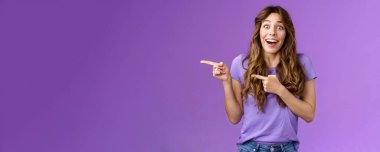 Şaşırtıcı bir şekilde memnun olmuş şanslı kız şaşırmış işaret parmaklarını açık açık göstererek solu işaret etmiş harika bir terfi almış hayranlık duyulan olumlu tutum..