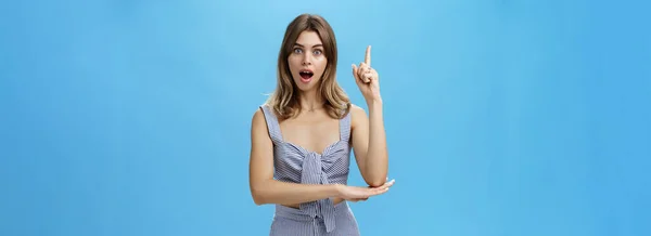 I got excellent idea. Portrait of polite adult straight A student raising index finger in eureka gesture wanting add suggestion asking permission to speak standing excited over blue background.