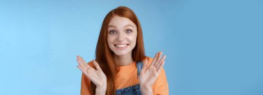 Gururlu, destekleyici, genç, kızıl saçlı kız arkadaş el çırpıyor, gülümsüyor, tebrik ediyor, başarılı oluyor, tezahürat yapıyor, harika performanslara katılıyor, mutlu bir şekilde alkışlıyor..