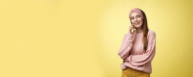 Çekici, çekici, çekici, 20 'li yaşlarda, süveter giyen, başını yana eğmiş, sırıtan, meraklı, akıllı telefondan hoş sohbetler yapan, arkadaşlarıyla konuşan Avrupalı bir kadın..