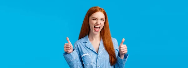You go girl, women power. Encouraged and optimistic good-looking redhead woman in nightwear assure everything awesome, promote great product, show thumbs-up in like or approval, wink.