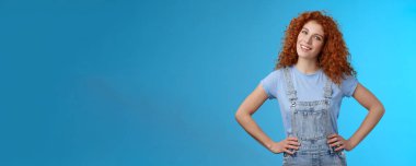 Neşeli, motive olmuş, çekici kızıl saçlı, kıvırcık saçlı, kızıl saçlı, el ele tutuşmuş, kendine güvenen, kendine güvenen, kendinden emin gülümseyen, ilham veren kız..