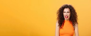 Dil çıkaran ve kaşlarını çatan kızlardan iğreniyor. Sevmediği şeyler hakkında konuşuyor. Arkadaşının turuncu arka planda yoğun ve tatminsiz durmasından.