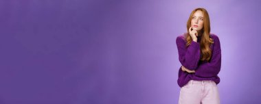 Düşünceli ve odaklanmış zeki, yaratıcı, kızıl saçlı ve çilli çekici bir kadın. Sol üst köşeye bakıyor. Düşünürken ya da plan yaparken, çene üstüne el ele tutuşup bir seçim yapmayı düşünüyor..