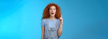 Yaşam tarzı. Etkilenmiş, kızıl saçlı, kıvırcık saçlı, Avrupalı bir öğrenci kot pantolon giyiyor. Tişört giyiyor. Ağzı açık..