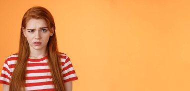 Aptal, kafası karışmış, kafası karışmış, kafası karışmış, kafası karışmış, kafası karışmış, kafası karışmış, saçmalıkları anlamayan, turuncu arka planı sorgulayan bir kadın..