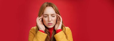 Düşünceleri bir arada tutmaya çalışan gergin ve bastırılmış hisseden, gözlerini kapatan, kaşlarını çatan, şakakları okşayan, baş ağrısı ya da migren hisseden, kırmızı arka plandaki düşüncelere odaklanan bir kız. Boşluğu kopyala