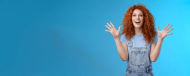 Karizmatik, neşeli, neşeli, kızıl saçlı, güzel, kızıl saçlı kız sevinçle alkışlıyor, gururla gülümsüyor, gülümsüyor, gülümsüyor, mutluluğunu ifade ediyor..