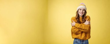 Üşümeye başladım. Çekici, çekici, sevimli, sevimli kız arkadaş kendini kucaklıyor, gülümsüyor, ılık bakışlar donuyor, örülmüş kazak, sarı arka plan..