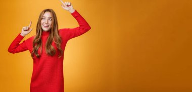 Çekici ve zarif kızıl saçlı, kırmızı örgü elbiseli kadın dans ederken kaygısızca ellerini kaldırıyor, memnun oluyor ve sol üst köşedeki geniş sırıtışla mutlu mesut bakıyor. Anlaşıldı.