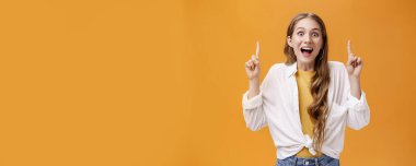 İyi tarafından bak. Karizmatik, mutlu, coşkulu, beyaz bluzlu, çekici bir kadın. Çenesi açık, neşeli bir gülümseme. Yükselmiş işaret parmaklarıyla işaret ediyor..