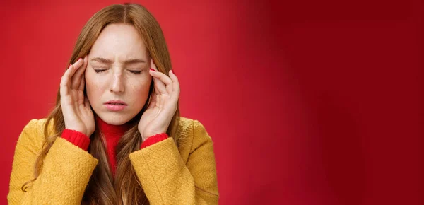Girl trying keep thoughts together feeling tensed and pressured close eyes frowning rubbing temples, feeling headache or migraine, focusing on thoughts over red background. Copy space