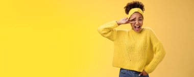 Sarı kazaklı Afro-Amerikan bayan öğrenci zafer jesti gösteriyor. Disko partisinden zevk alarak, neşeyle gülümseyin, neşeyle..