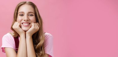 Yaşam tarzı. Sevimli, kadınsı, dövmeli, dalgalı saçlı, başını yana eğmiş güzel bir kız. Sanki dinliyormuş gibi. Geniş gülümsemeli, hayranlık dolu bakışları pembe arka planda rüya gibi.