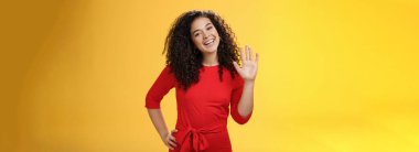 Hey, benim adım. Arkadaş canlısı, kendine güveni tam, 25 'li yaşlarda, kıvırcık saçlı, el sallayan, sarı arka plandaki yeni iş arkadaşlarını selamlayan bir kadın..