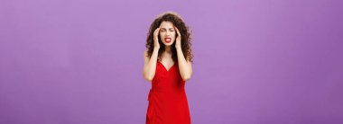 Odaklanmaya çalışan ve düşünceleri bir araya getiren bir kadın şakakların üzerinde parmaklarını tutarak baskı hisseden bir kadın. Ve dişlerini sıkarak gözlerini kapatıyor. Mor arka planda şiddetli migren ve baş ağrısı ile ayakta duruyor.