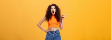 Kıvırcık saçlı, aptal ve dengesiz Avrupalı parti kızı. Kırmızı rujlu ve şık portakallı üst taraf kötü havadan şikayet ediyor, elleri kaldırıyor ve mutsuz bir yüzle yukarı bakıyor..