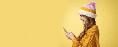 Profil, sempatik, rahat, çağdaş genç bir kızı elinde akıllı telefonuyla gülümseyerek mesajlaşırken, eğlenceli bir kurgu resmi görüntülerken çekti. İnternet 'te blogcu mesajlaşmacı takipçileri.