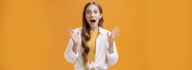 Neşeli ve heyecanlı, hayat dolu, büyüleyici kıyafetli güzel bir kadının portresi. Yırtık elleri açık, ağzı açık, şaşkınlıktan ağzı açık. Arkadaşına harika haberler veriyor..