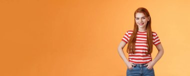 Yetenekli, motive olmuş, neşeli, kızıl saçlı, el ele tutuşmuş, gülümseyen, güçlü, profesyonel girişimci, tek başına iş çevirmekten memnun, iyi bir başlangıç, turuncu arka plan..