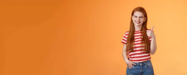 Neşeli, dost canlısı, kızıl, doğal, temiz ten, baş parmağını kaldır, gülümse, mükemmel seçimi destekle, mükemmel performans gibi, pozitif görüş, kabullenme, turuncu arka plan.