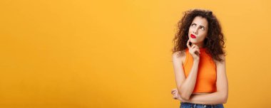 Belden yukarı vuruşlar, şaşkın ve düşünceli. Kıvırcık saçlı, kırmızı rujlu ve üstü açık bir kadın çenesine dokunuyor sol üst köşeye bakıp kaşlarını çatıyor.