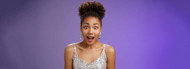 Yakın plan Afro-Amerikan etkilenmiş, ağzı açık, ağzı açık genç bir kız şaşırmış, ağzı açık, şaşkın, şaşkın bakışları şaşkın, ilginç bir teklif, mavi arka plan..