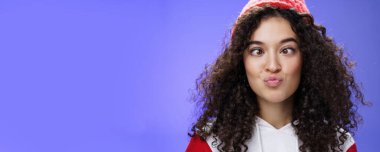 Komik ve şakacı bir kızın şaklabanlık yapıp suratını buruşturması korkmamak ördek gibi kıvrılmış dudaklar ve şaşı buz, çocuksu ve komik bir şekilde mavi şapkalı duvarın üzerinde dikilmesi..