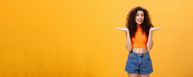 Üzgünüm, tatlım. Kıvırcık saçlı, silkelenmiş silkelenmiş silkelenmiş, elleri yana açılmış aptal Avrupalı bir kadın suçlu gülümsüyor ve turuncu arka planda sorgulanıyor..